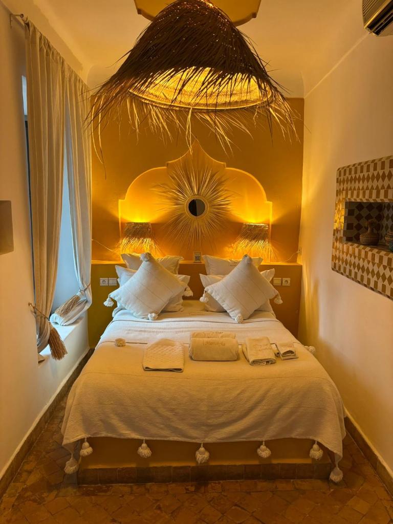 une chambre avec un grand lit avec un miroir au mur dans l'établissement Riad Dar Marrakcha, à Marrakech