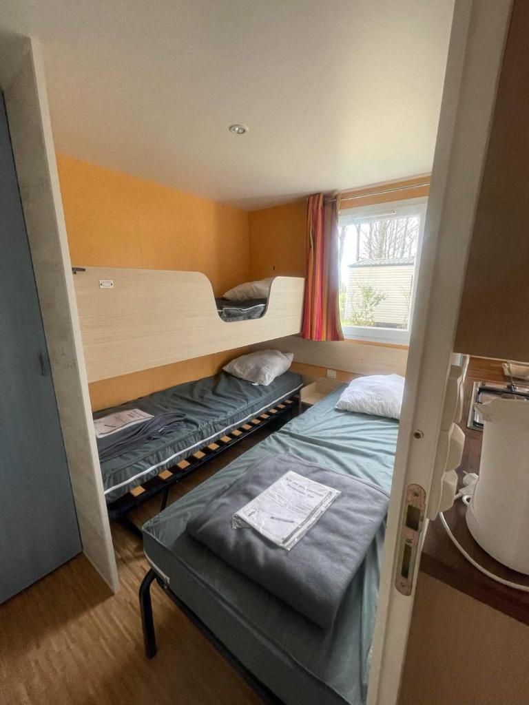 une chambre avec deux lits superposés et une fenêtre dans l'établissement Mobilhome 5P proche Puy duFou 120CV, à La Boissière-de-Montaigu