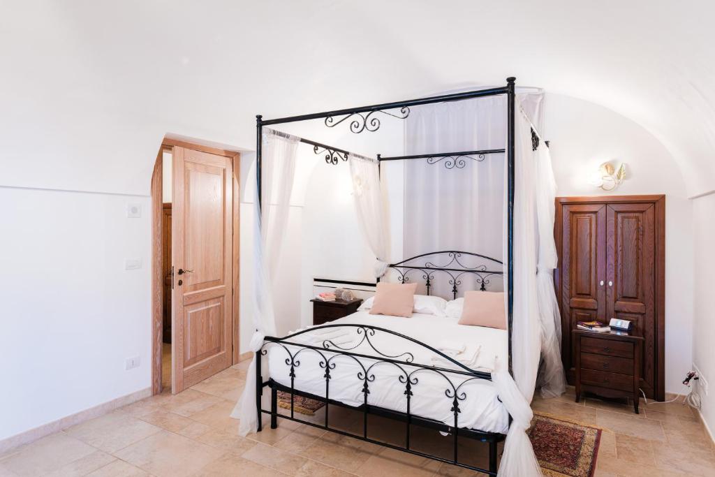 - une chambre avec un lit à baldaquin noir et des oreillers roses dans l'établissement Villa Donna Franca by STHEY, à Monopoli