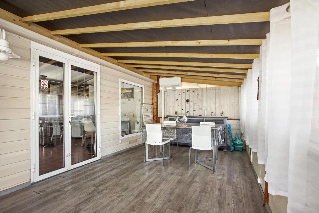 une cuisine avec des chaises blanches et une table dans l'établissement Mobilhome Puget-sur-argens, à Puget-sur Argens