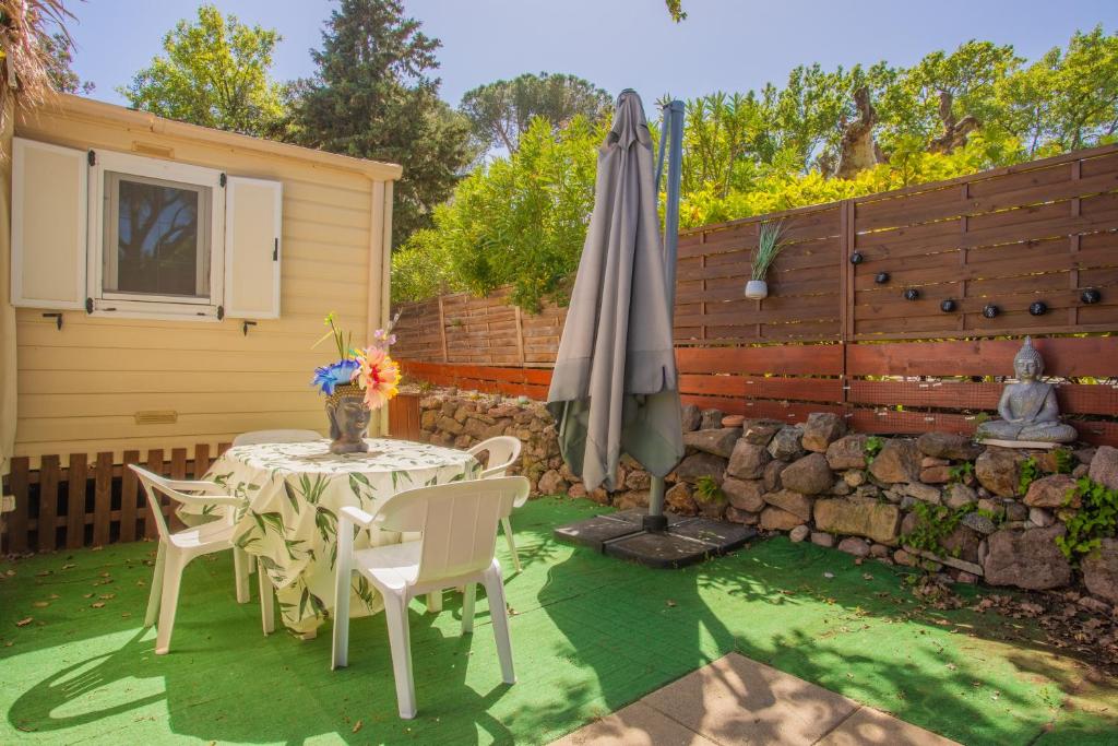un patio avec une table et un parasol dans l'établissement Mobilhome Puget-sur-argens, à Puget-sur Argens