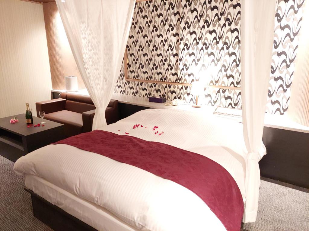 une chambre avec un lit avec un rideau et une fenêtre dans l'établissement Hotel Lara Ciel, à Matsumoto