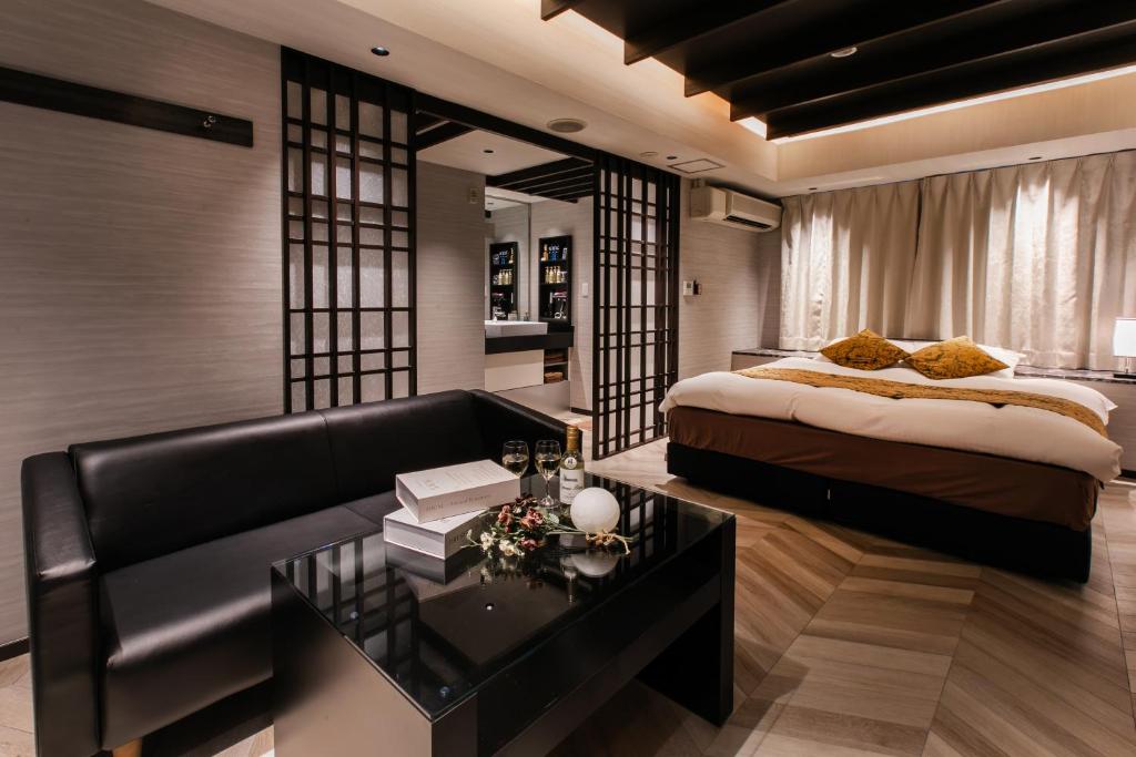 une chambre avec un lit, un canapé et une table dans l'établissement ホテルジップスタイル, à Sendohira