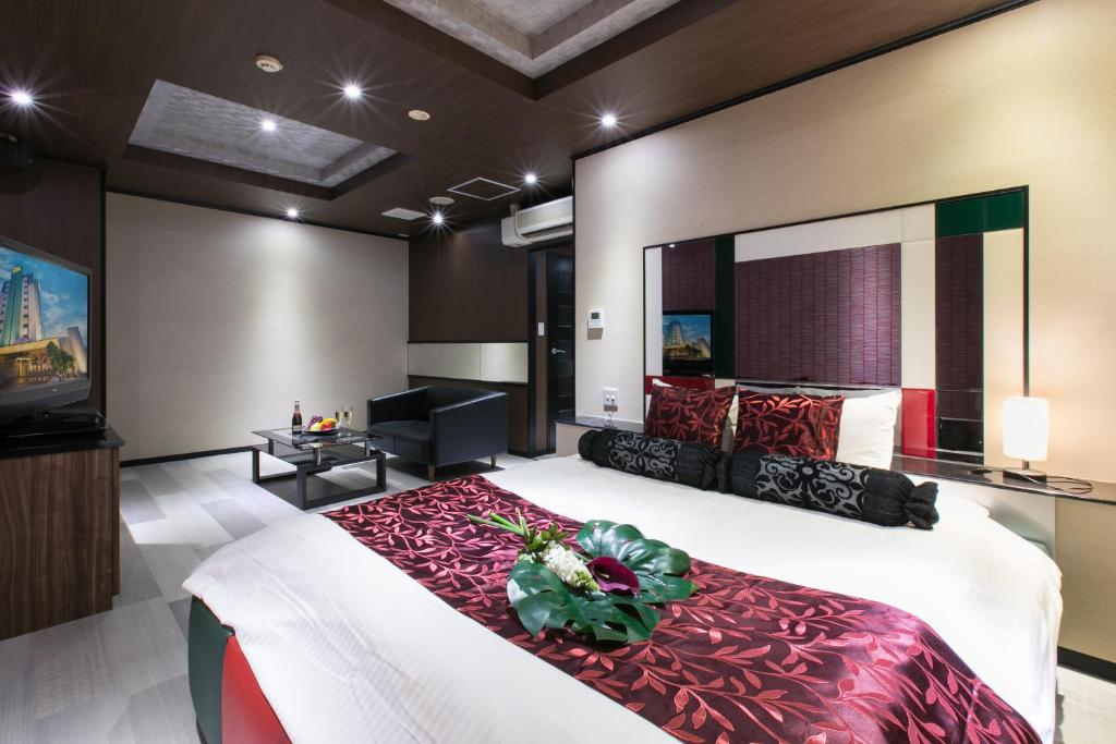 une chambre avec un grand lit et une télévision à écran plat dans l'établissement ホテルジップスタイル, à Sendohira