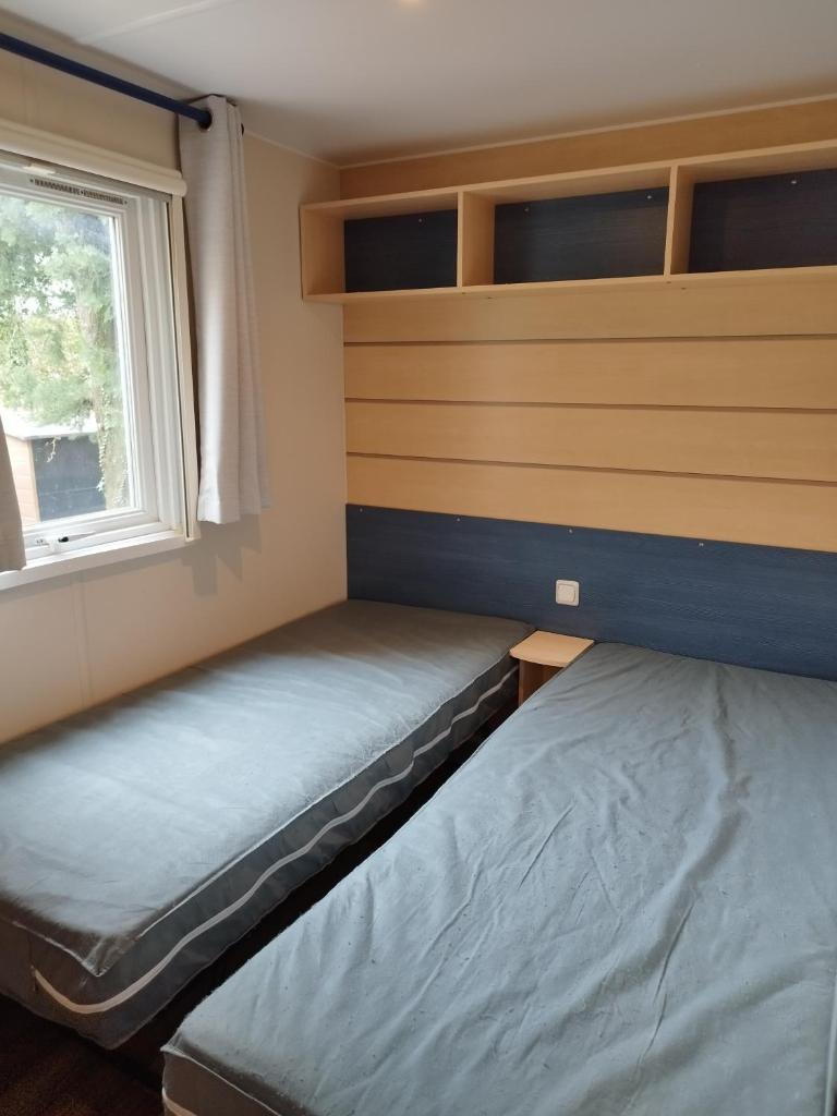 une petite chambre avec deux lits et une fenêtre dans l'établissement Comme Chez Vous, à La Roque-dʼAnthéron