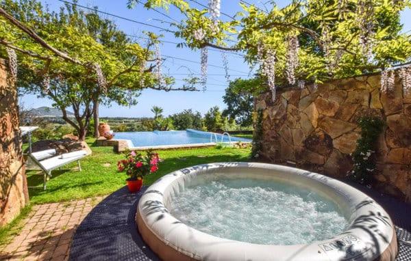 - un bain à remous dans une cour à côté d'une piscine dans l'établissement GreenVilla, à La Caletta