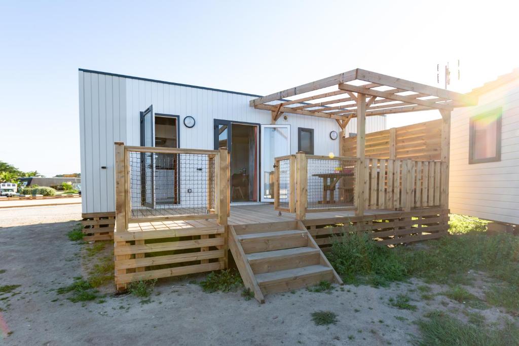 une terrasse avec pergola sur une maison dans l'établissement Camping Paradis Baie de Ploemeur, à Ploemeur