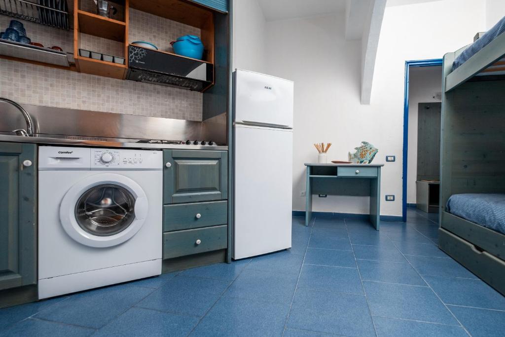 une cuisine avec un lave-linge et un réfrigérateur dans l'établissement Oasi Azzurra, à Messina