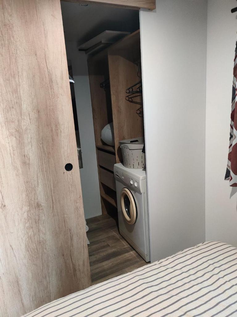une chambre avec une machine à laver dans un placard dans l'établissement Jolie Mobil Home climatisé 58, à Saint-Jean-de-Monts