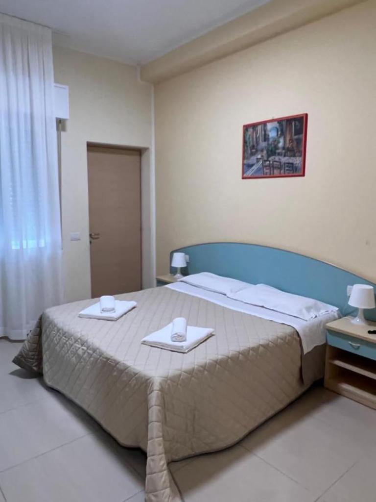 une chambre avec un grand lit avec deux serviettes dessus dans l'établissement HOTEL CUBA nuova gestione, à Rimini