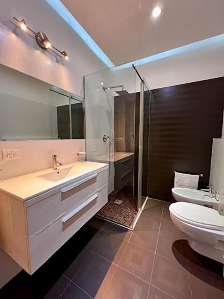 une salle de bain avec un lavabo, des toilettes et une douche dans l'établissement HOTEL CUBA nuova gestione, à Rimini