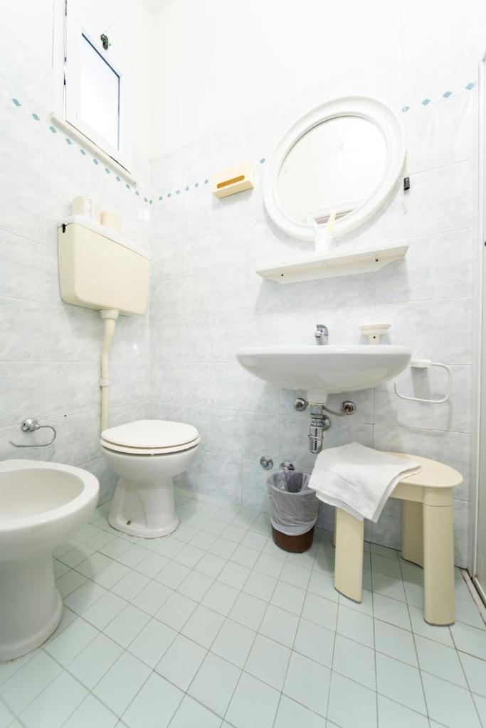une salle de bain blanche avec toilettes et lavabo dans l'établissement Hotel Cortina, à Rimini 35 autres photos
