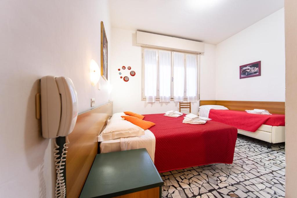 une chambre d'hôtel avec deux lits et un téléphone dans l'établissement Hotel Cortina, à Rimini