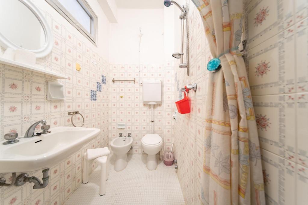 une salle de bain avec un lavabo et des toilettes dans l'établissement Hotel Cortina, à Rimini