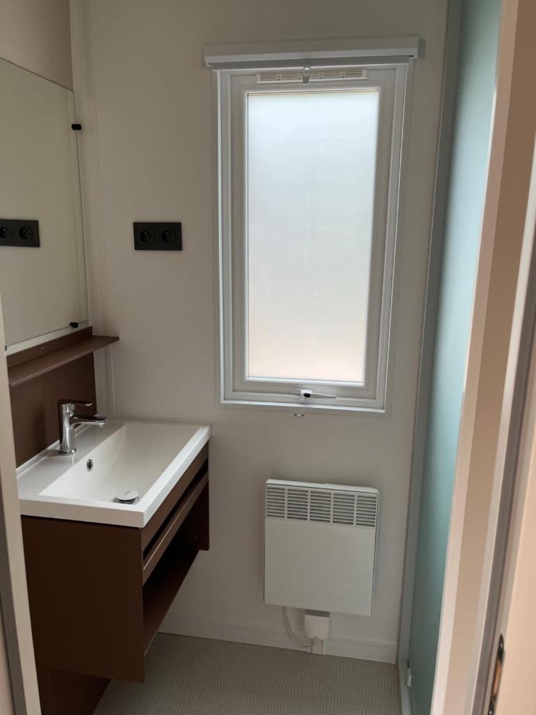 une salle de bain avec un lavabo et une fenêtre dans l'établissement Mobil home tout confort côte bleue, à Carry-le-Rouet