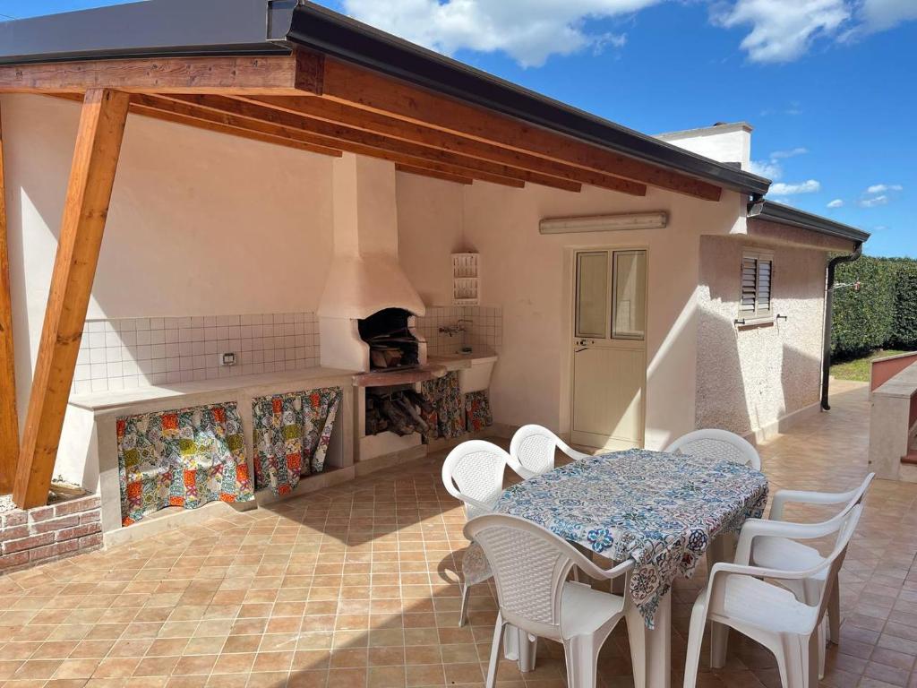 une terrasse avec une table, des chaises et une cuisinière dans l'établissement Villa Amos Marzamemi San Lorenzo, à Reitani