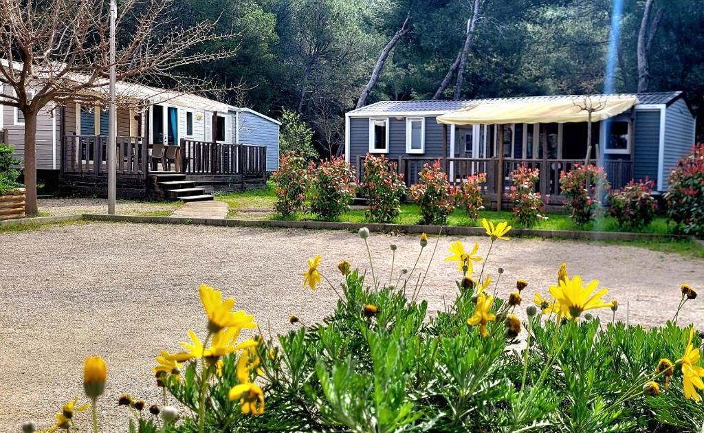 un groupe de maisons et de fleurs dans une cour dans l'établissement Camping Aux Portes De Cassis, à La Bédoule