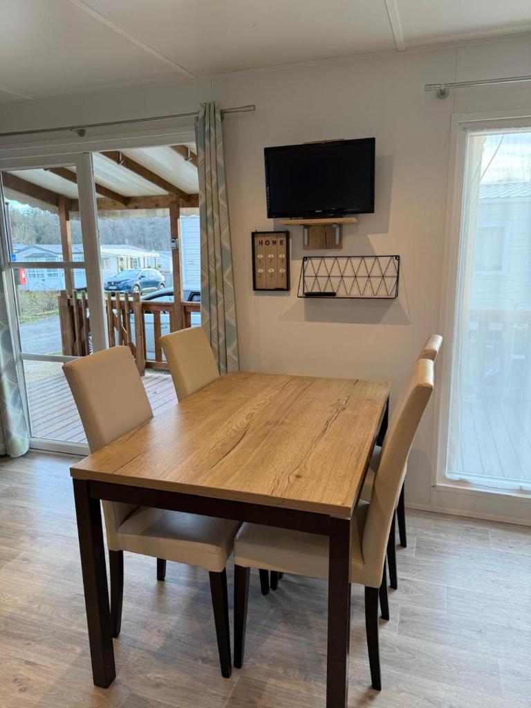une table à manger avec des chaises et une télévision murale dans l'établissement camping onzain 4 etoiles, à Onzain