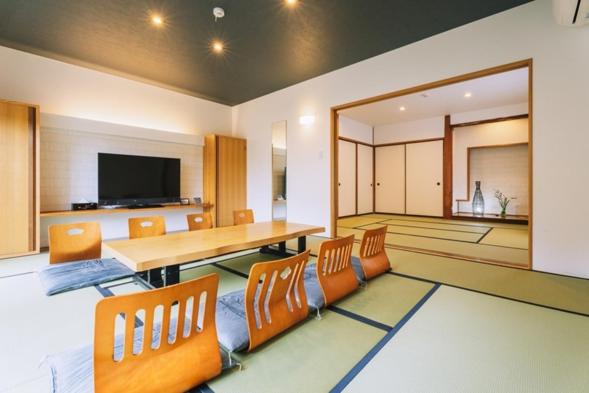 une pièce avec une table, des chaises et une télévision dans l'établissement Chikurakutei, à Minami Aso