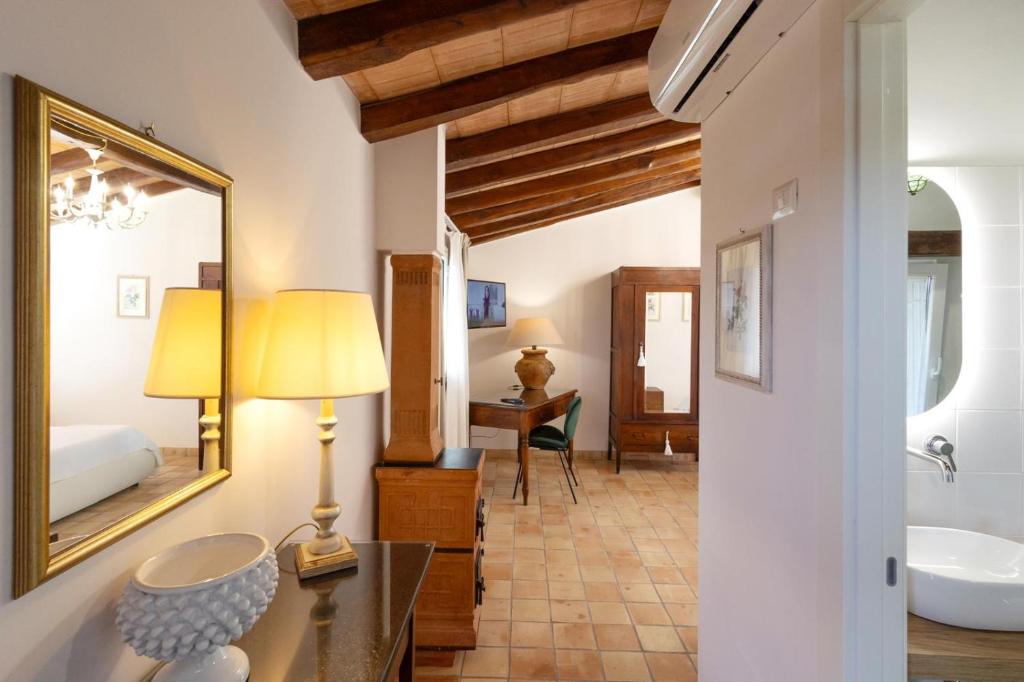 une salle de bain avec un lavabo, un miroir et un lit dans l'établissement Villa Alcantara di Charme, à Graniti