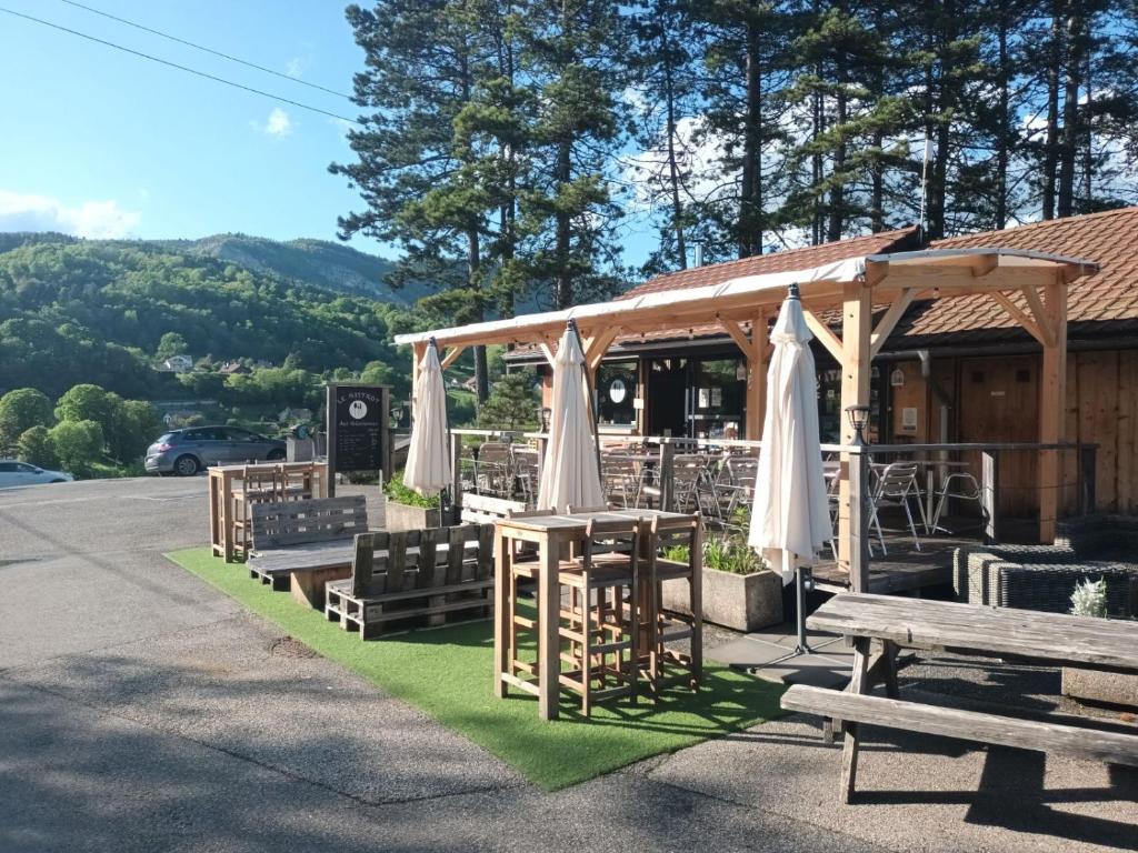 - un pavillon avec une table, des chaises, une table et des bancs dans l'établissement Cabane en bois POD 1, à Champfromier