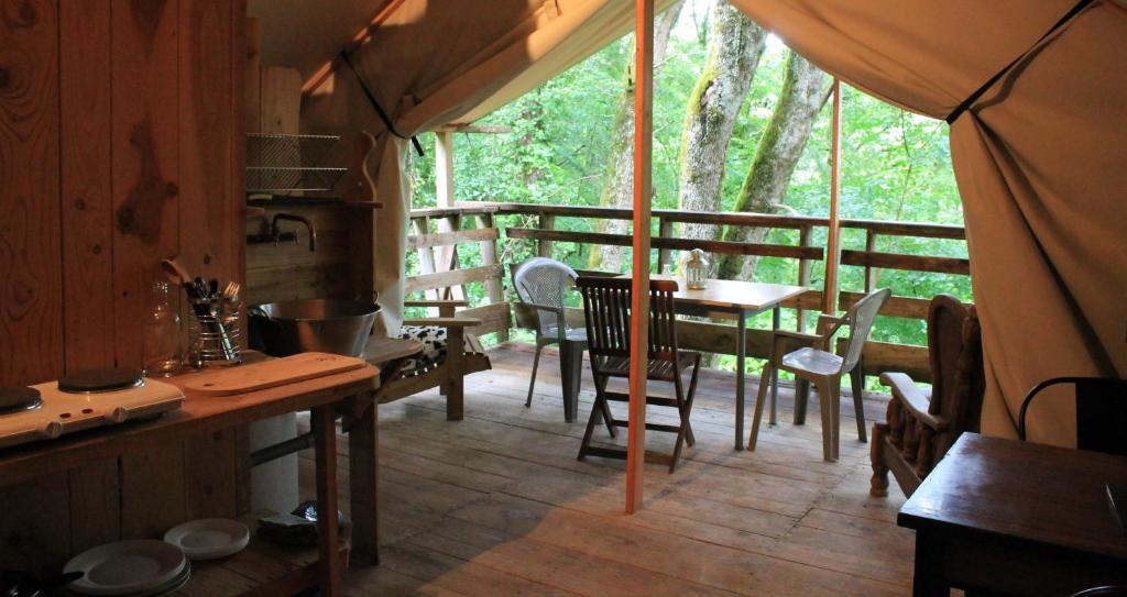 une chambre avec une table et des chaises dans une tente dans l'établissement Camping Terre Rouge, à Villecomtal