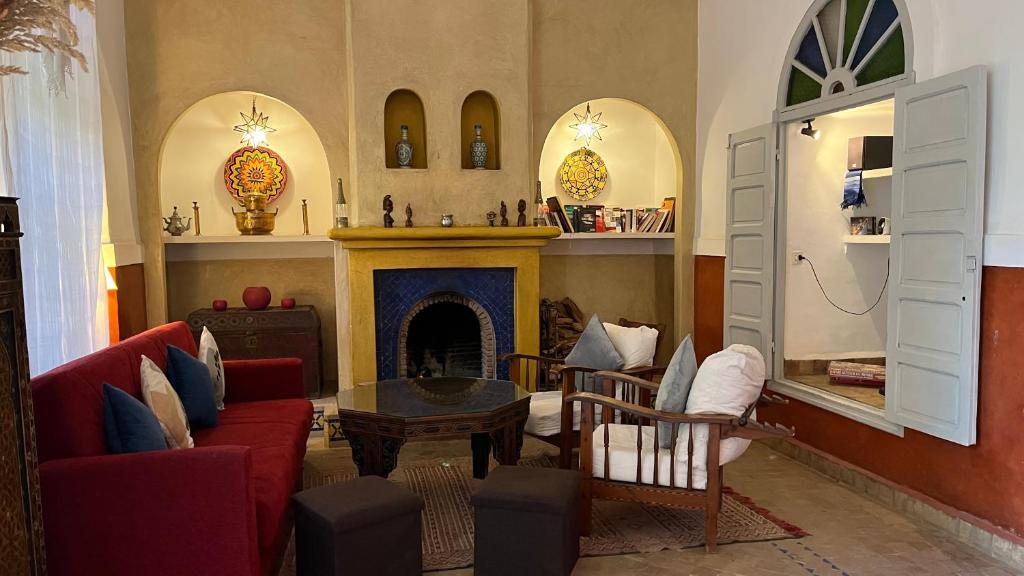un salon avec une cheminée et des chaises rouges dans l'établissement Riad Laila, à Marrakech