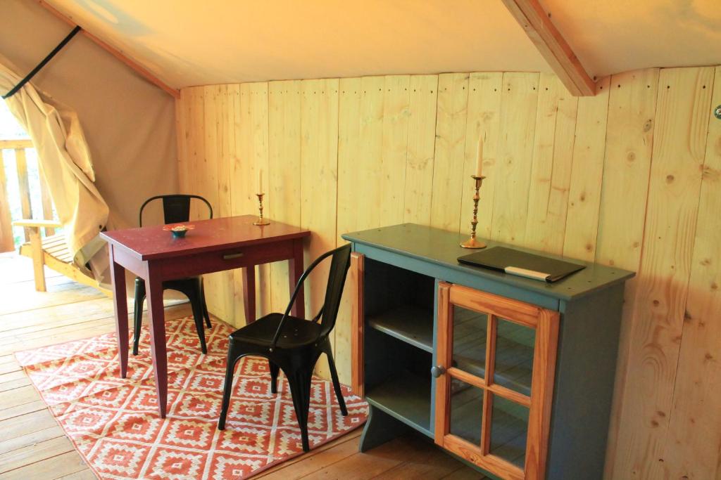 une pièce avec un bureau, une table et une chaise dans l'établissement Camping Terre Rouge, à Villecomtal