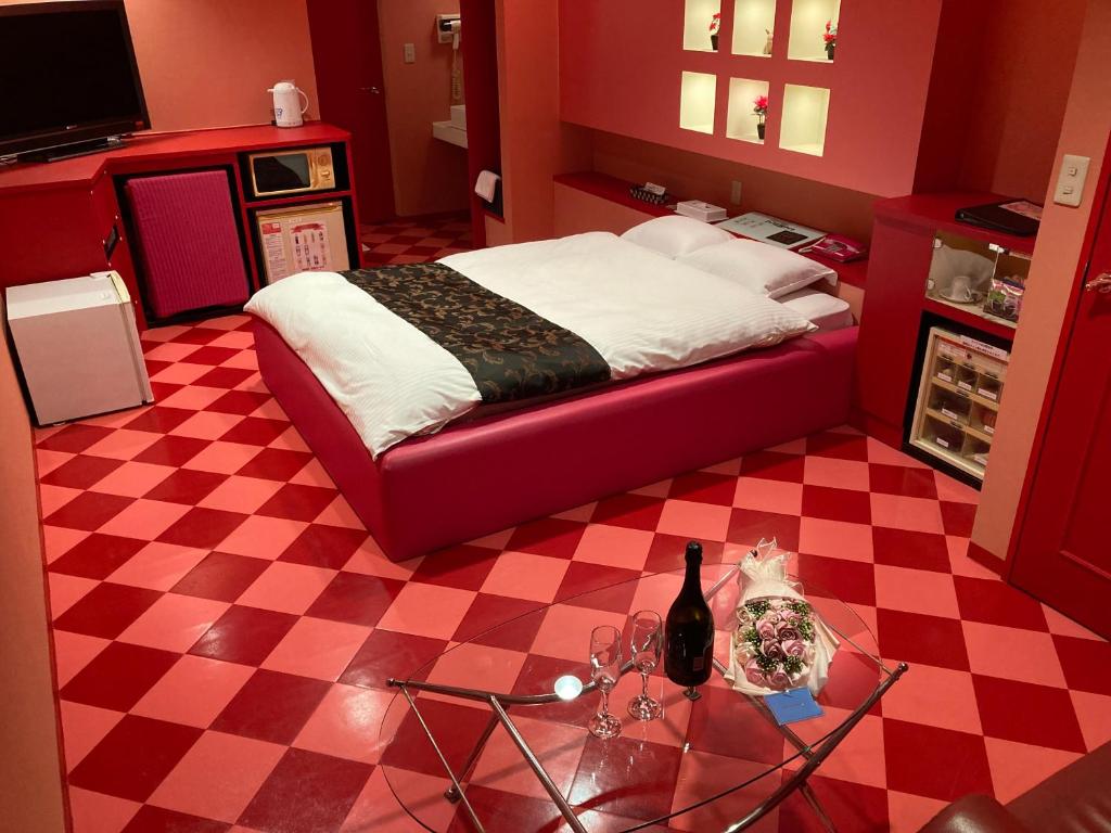 - une chambre avec un lit et une table avec une bouteille de vin dans l'établissement Hotel MGM, à Niigata