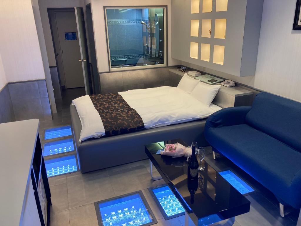 une chambre avec un lit, un canapé et une télévision dans l'établissement Hotel MGM, à Niigata