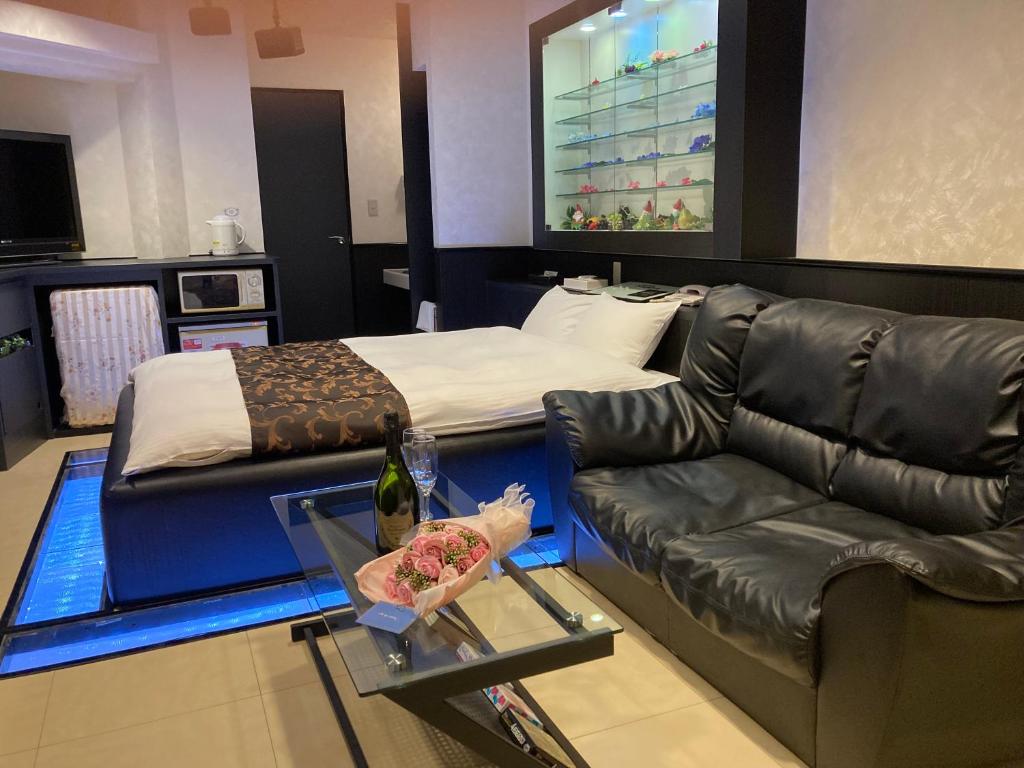 un salon avec un canapé et un lit dans l'établissement Hotel MGM, à Niigata 11 autres photos