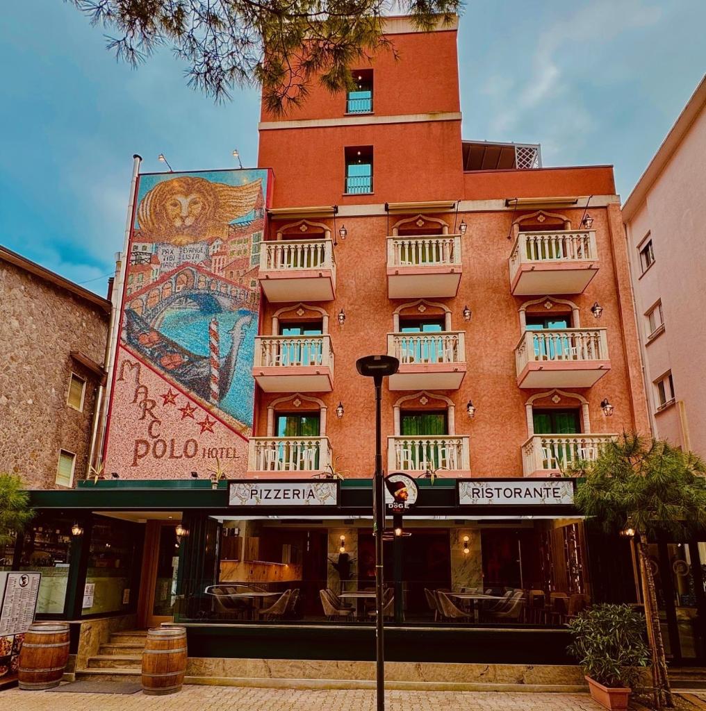 un bâtiment avec une peinture murale sur le côté dans l'établissement Hotel Marco Polo 3 Stelle Superior, à Lido di Jesolo