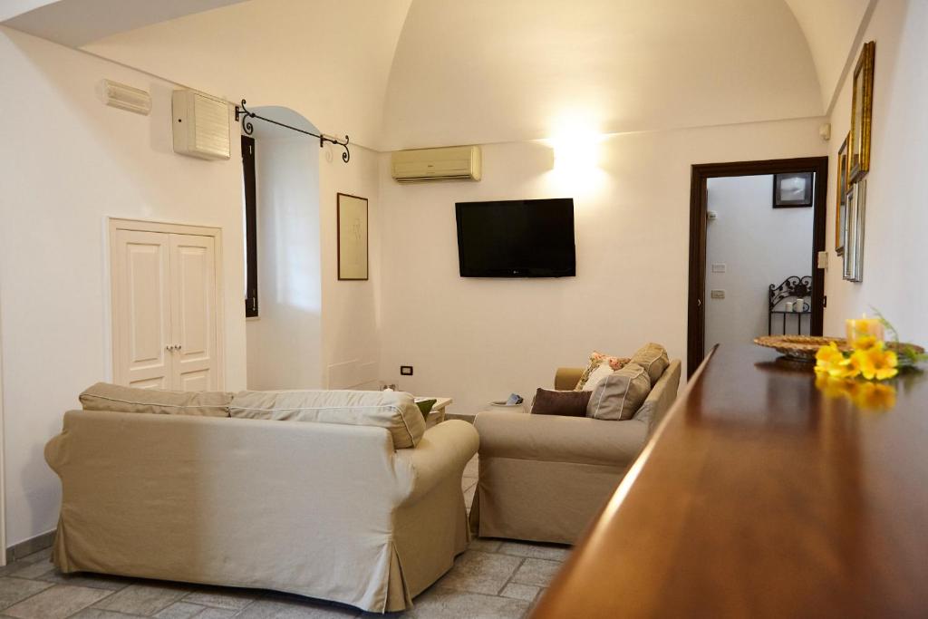 un salon avec un canapé et une télévision au mur dans l'établissement Villa Carrubo Peroscia by STHEY, à Padresergio