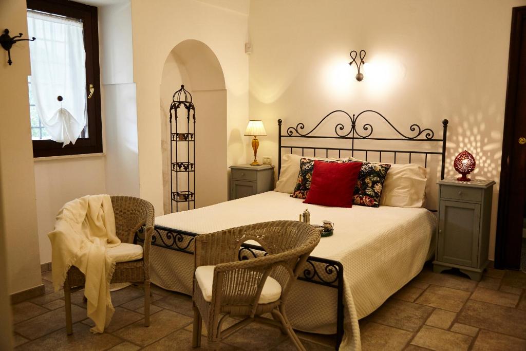 une chambre avec un lit avec deux chaises et une table dans l'établissement Villa Carrubo Peroscia by STHEY, à Padresergio