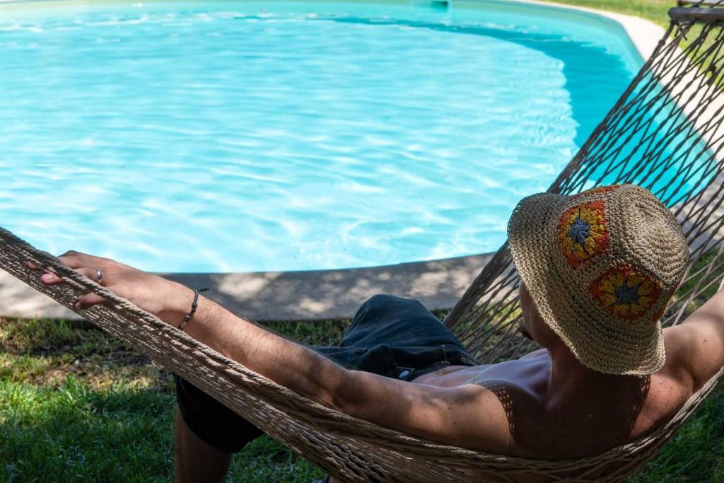 - un homme assis dans un hamac à côté d'une piscine dans l'établissement Relais Virginia Sea & Pool, Marsala, à Marsala