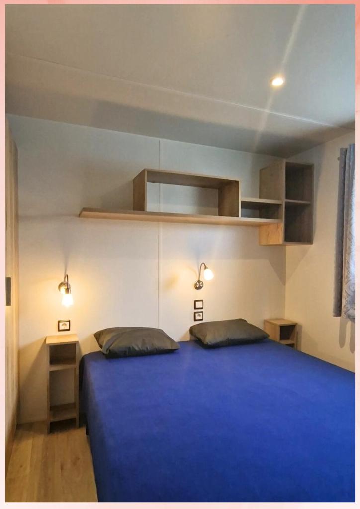 - une chambre avec un lit bleu et 2 oreillers dans l'établissement Les Sables du Midi, Agréable Mobilhome 6 personnes Valras Plage, à Valras-Plage