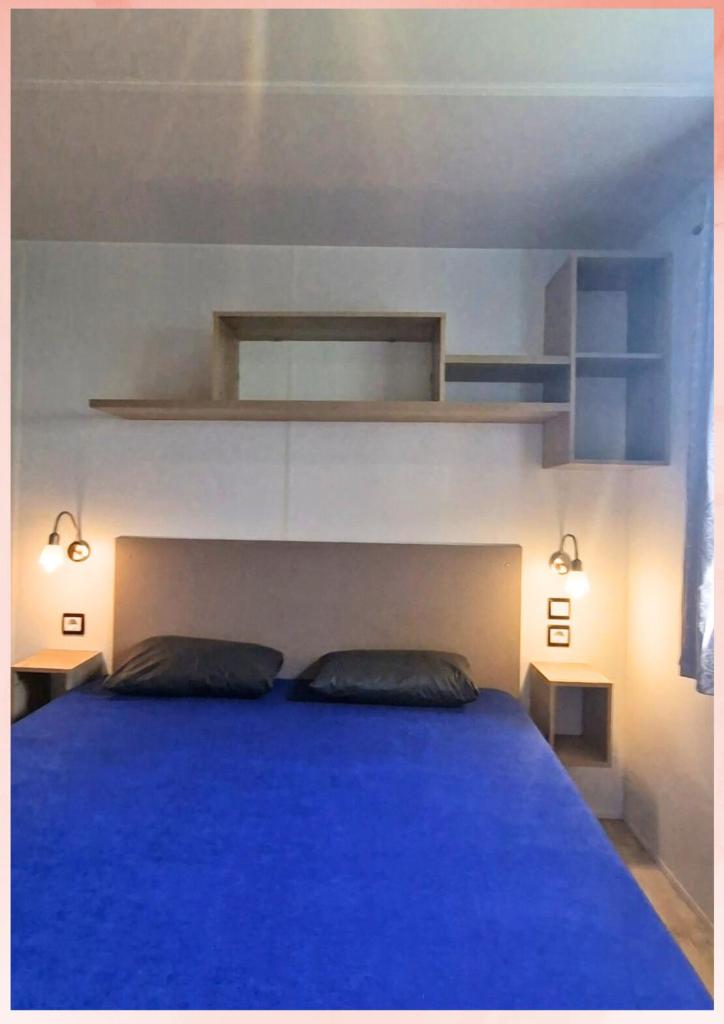 - une chambre avec un lit bleu et 2 oreillers dans l'établissement Les Sables du Midi, Agréable Mobilhome 6 personnes Valras Plage, à Valras-Plage 32 autres photos