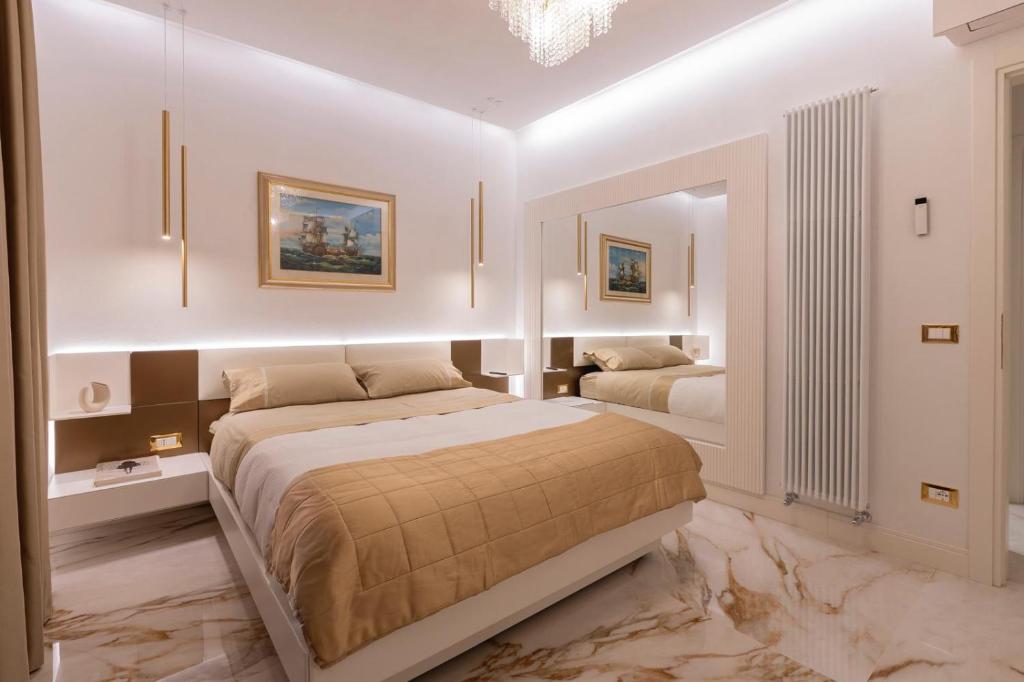 - une chambre blanche avec 2 lits et un miroir dans l'établissement Villino Peca, à Forte dei Marmi