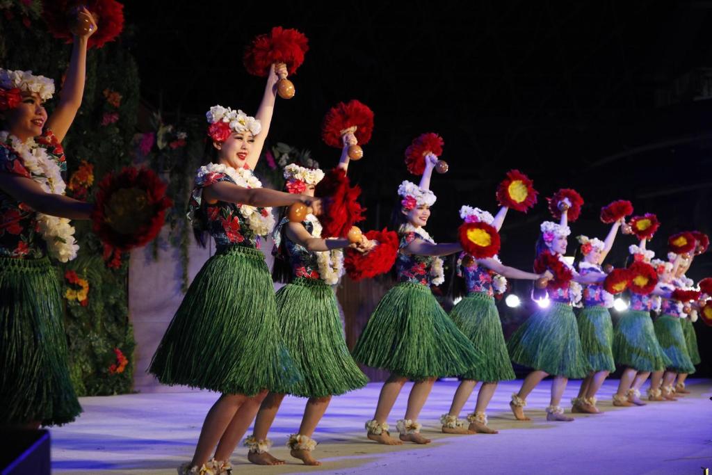 Un groupe de femmes portant des robes vertes sur une scène dans l'établissement Spa Resort Hawaiians Hotel Hawaiians, à Iwaki
