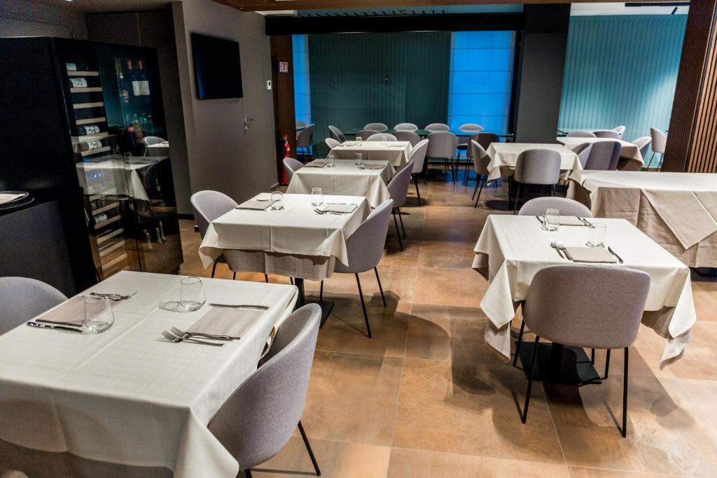 une salle à manger avec des tables et des chaises blanches dans l'établissement Lumia Hotel, à Termoli