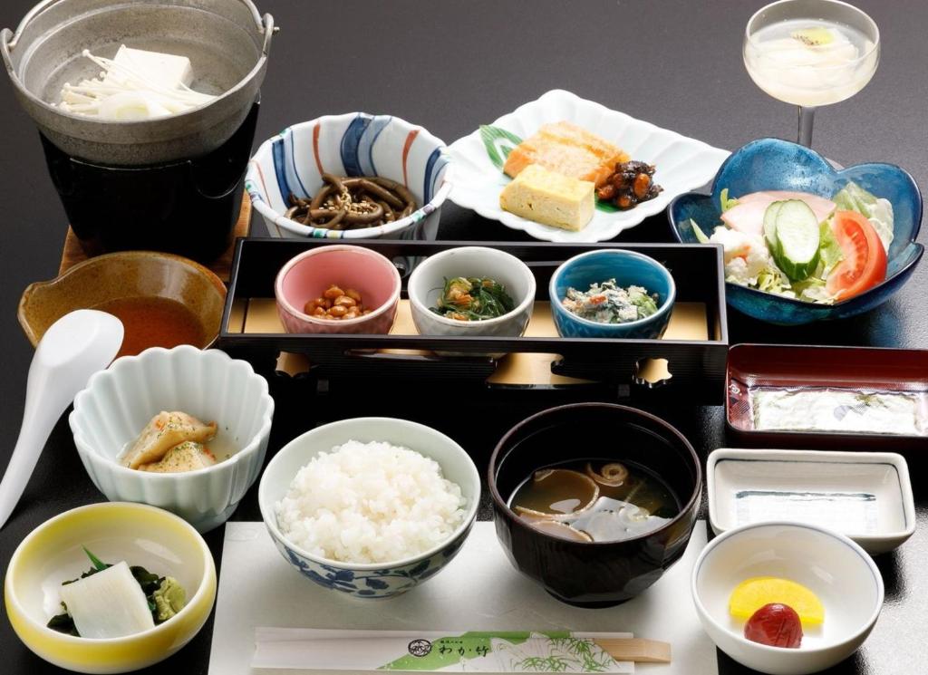 un groupe de bols de nourriture sur une table dans l'établissement Wakatake, à Tagami 14 autres photos