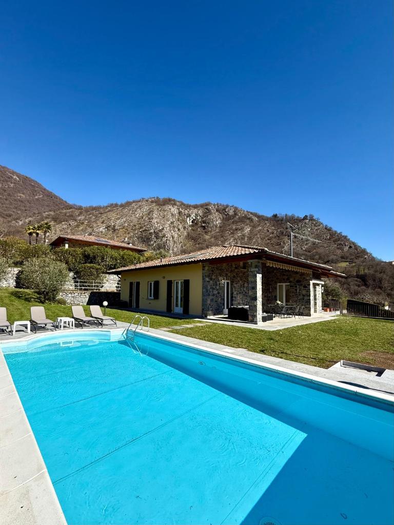 une grande piscine bleue devant une maison dans l'établissement Villa Charme, à Tremezzo