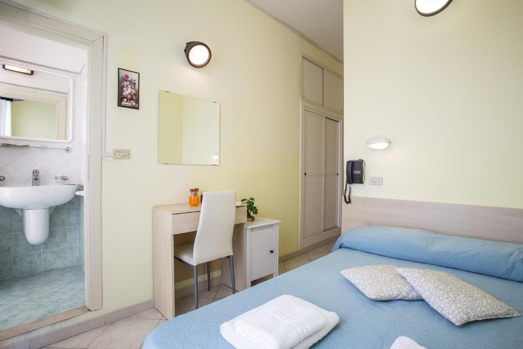 - une chambre avec un lit bleu et un lavabo dans l'établissement Hotel Sant'Angelo, à Riccione