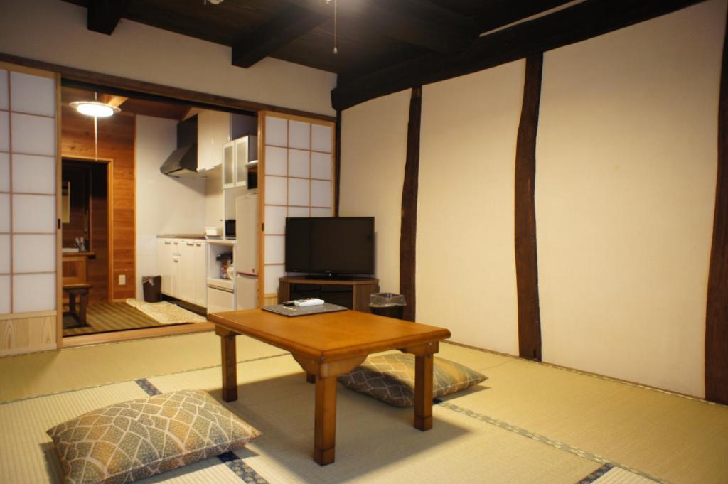 un salon avec une table et une télévision dans l'établissement Tabinoyado Kiunsoh, à Ōda
