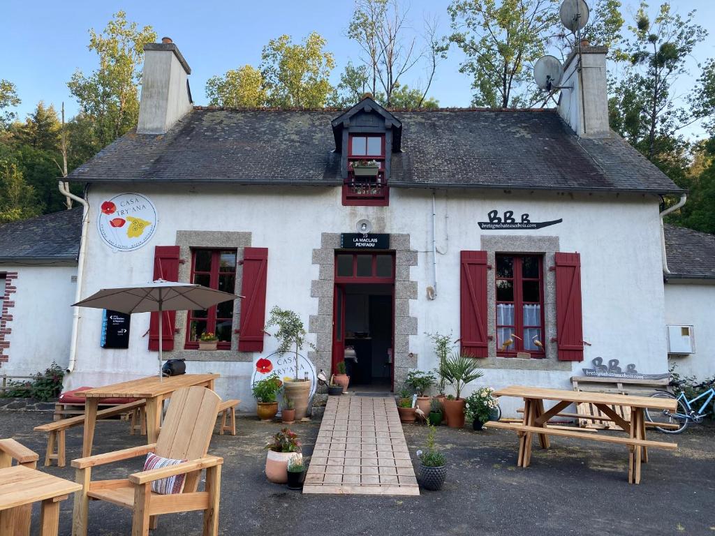 un bâtiment avec des tables de pique-nique devant dans l'établissement Patouillet bateau naviguant, à Saint-Vincent-sur-Oust
