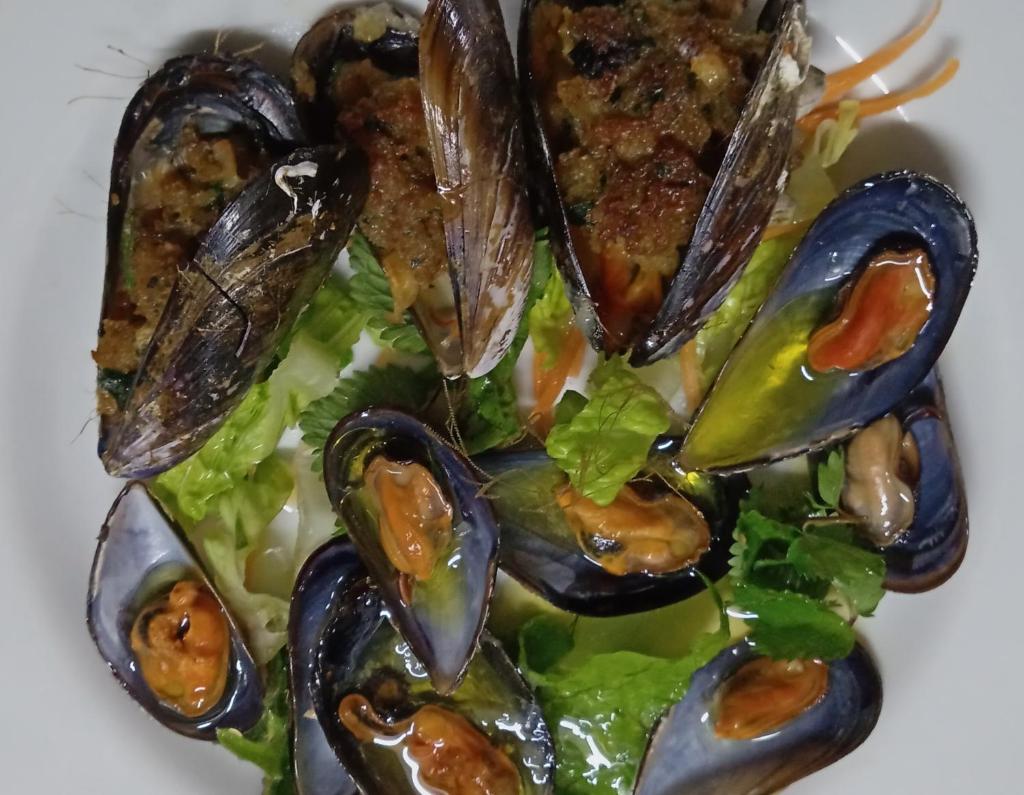 un plat avec des moules et une salade dans l'établissement Hotel Ristorante Sturno, à San Menaio