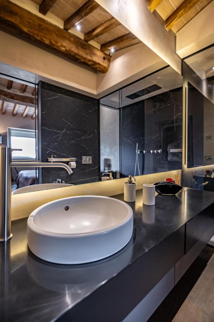 La salle de bains est pourvue d'un grand lavabo blanc sur un comptoir. dans l'établissement YD exclusive design villa Agati, à Castiglion Fiorentino