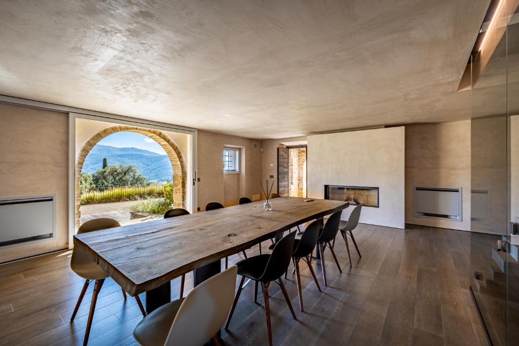 une grande salle à manger avec une grande table et des chaises en bois dans l'établissement YD exclusive design villa Agati, à Castiglion Fiorentino