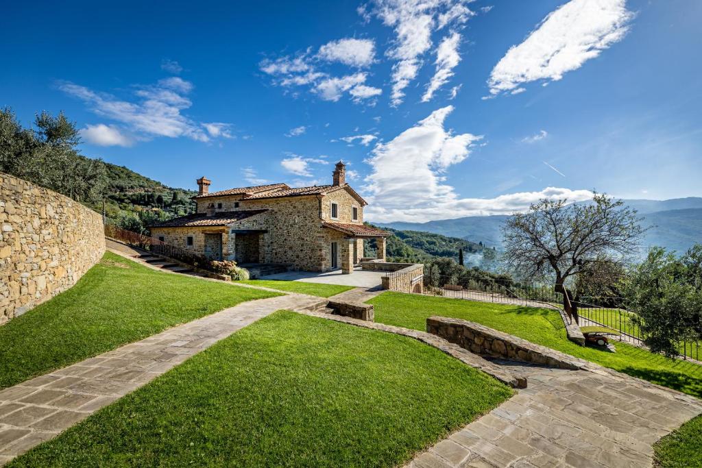 - une vue sur l'extérieur d'une maison avec des montagnes en arrière-plan dans l'établissement YD exclusive design villa Agati, à Castiglion Fiorentino