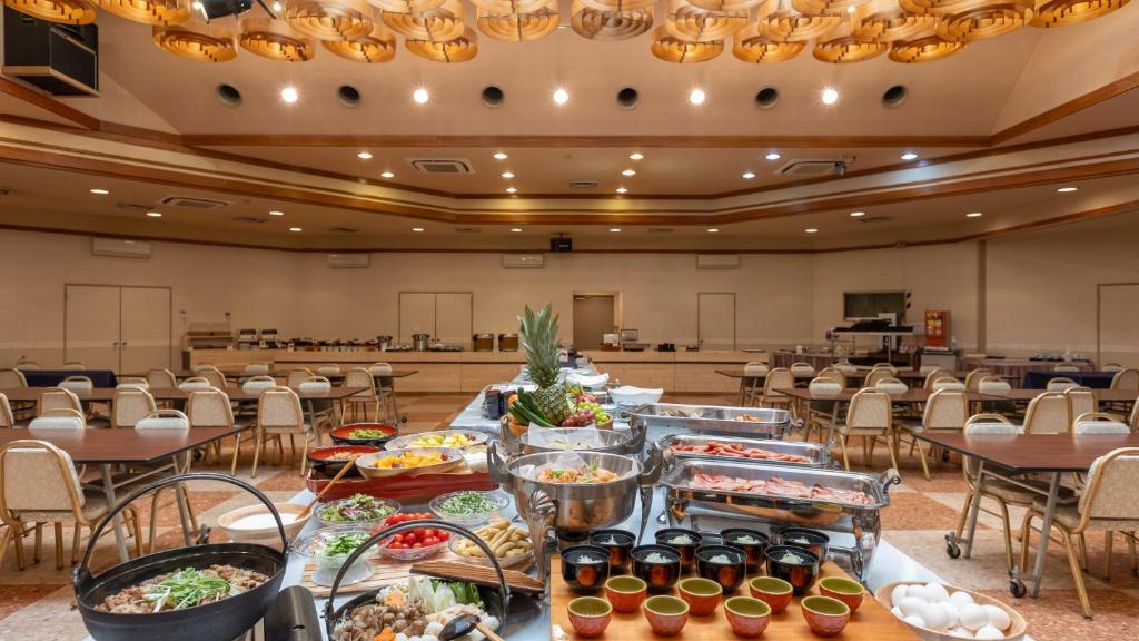 - un buffet de plats dans une grande salle dotée de tables et de chaises dans l'établissement KAMENOI HOTEL Akita Yuze, à Kazuno